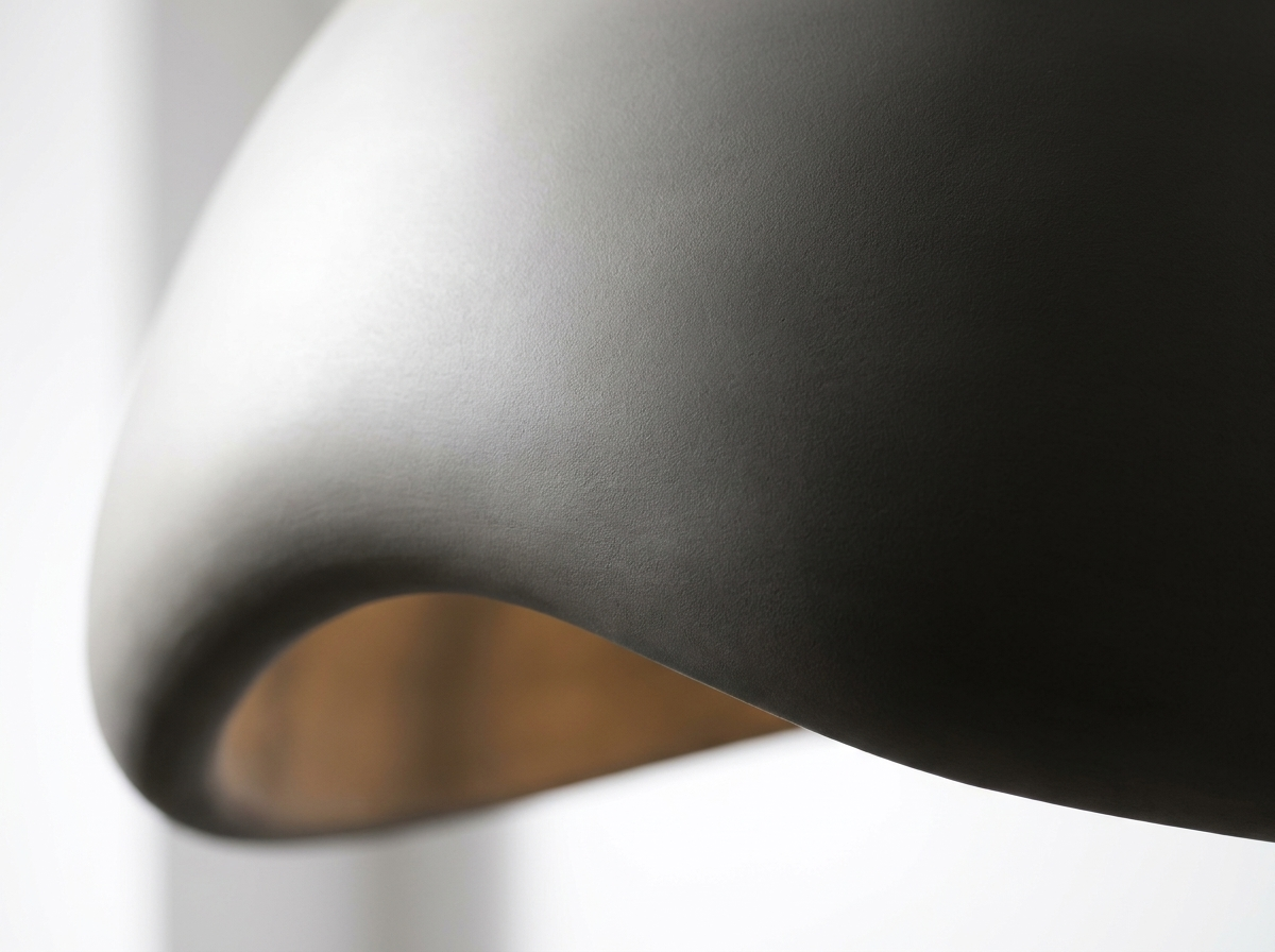 Close-up of the smooth sculptural resin pendant shade with dramatic showcase lighting